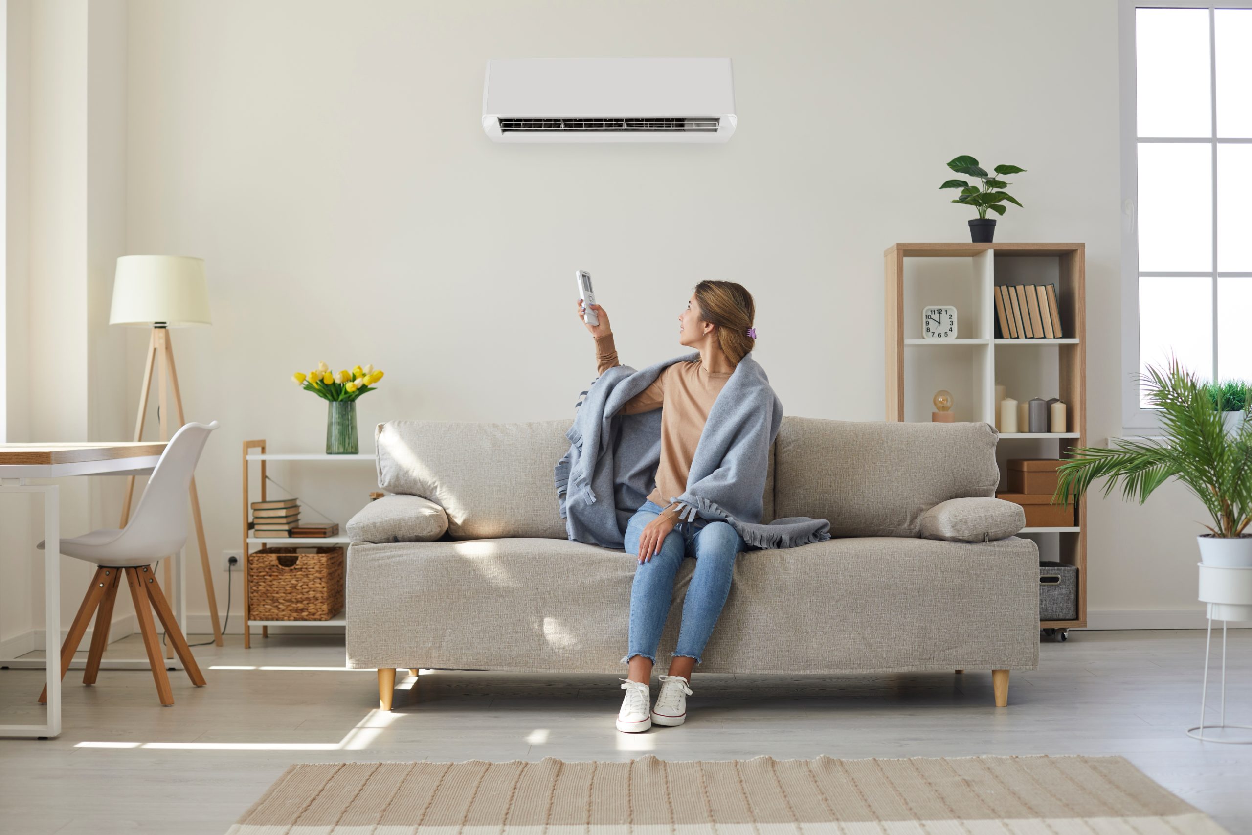 women on couch with blanket and heat pump unit on wall