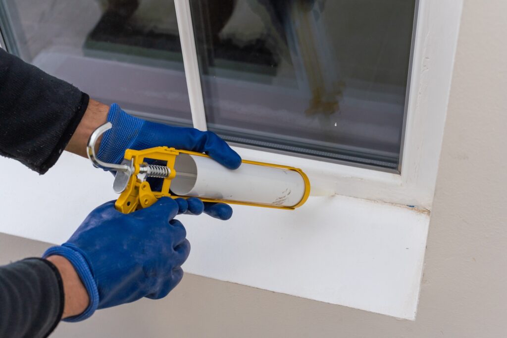 worker air sealing window in home