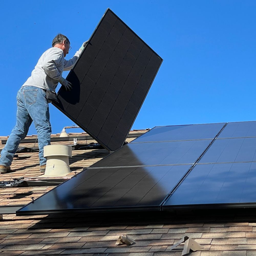 person installing solar panels on roof