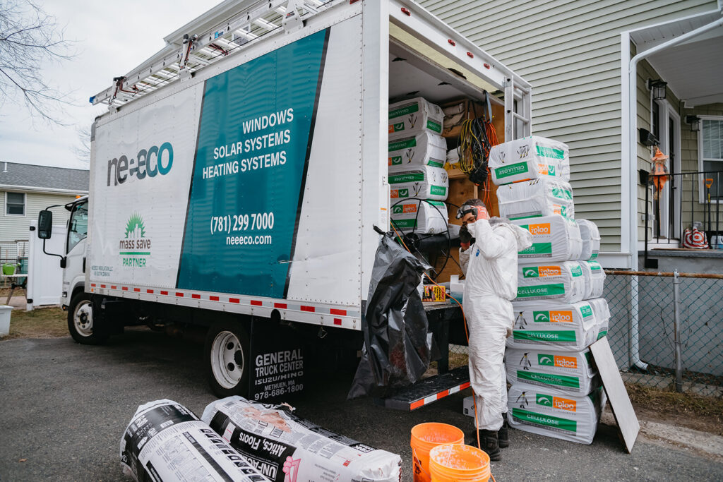 Insulation technician unloading branded Neeeco truck