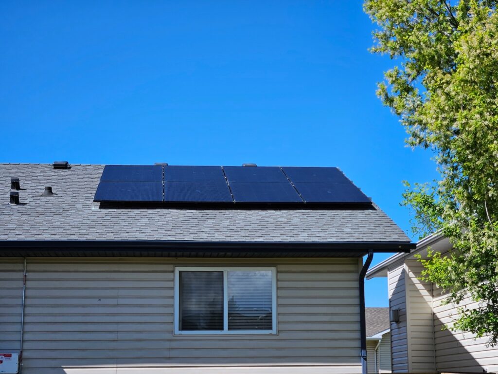 Eight solar panels installed on the roof of a residential single family bungalow.