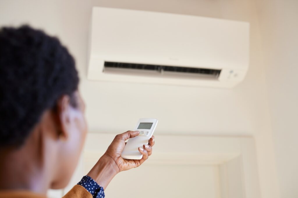 women adjusting her heat pump to make home comfortable