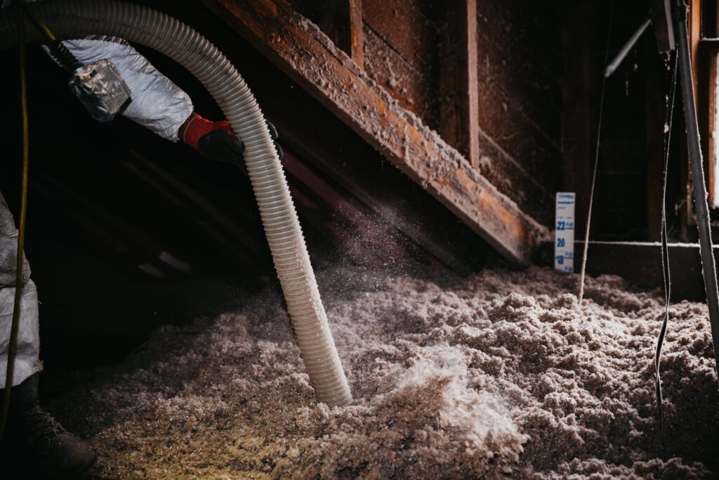Neeeco employee blowing cellulose insulation in MA attic